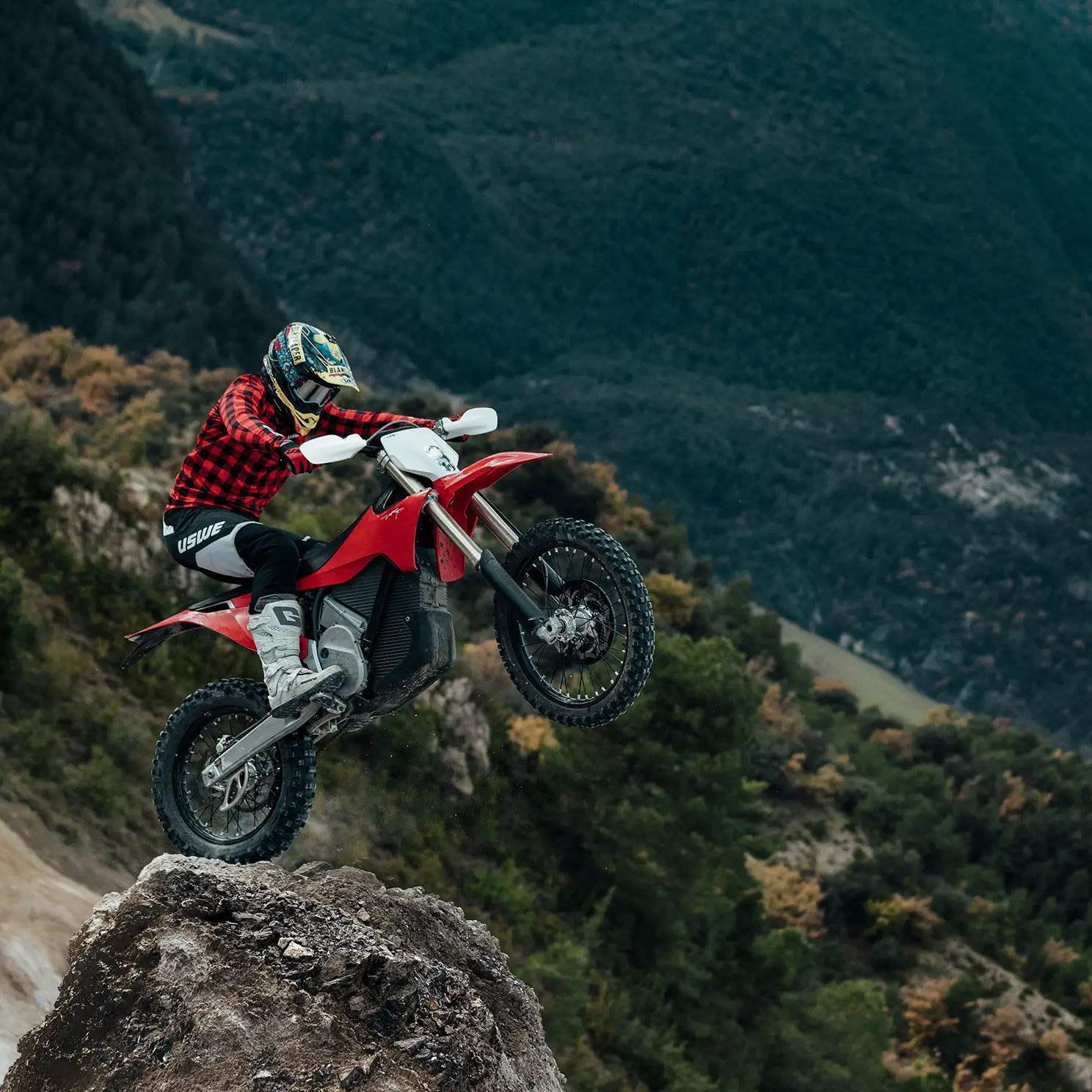 A rider on a red VARG climbing a rocky hillside.