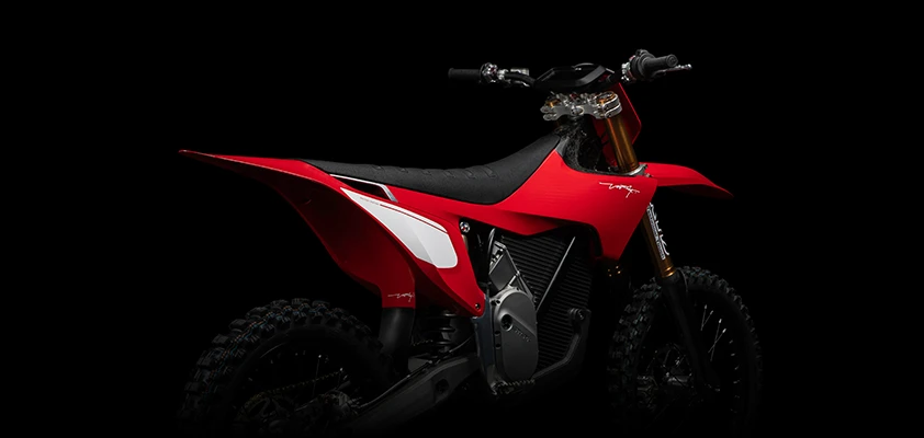 Left-side profile of the Stark VARG Factory Edition highlighting the 80hp ALPHA electric drivetrain — Factory Red electric motocross bike on neutral background