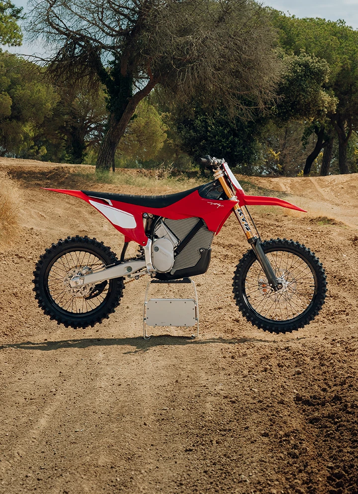 Stark VARG Factory Edition sur terrain sablonneux en conditions réelles — profil droit complet, coloris Factory Red, moto de motocross électrique ALPHA